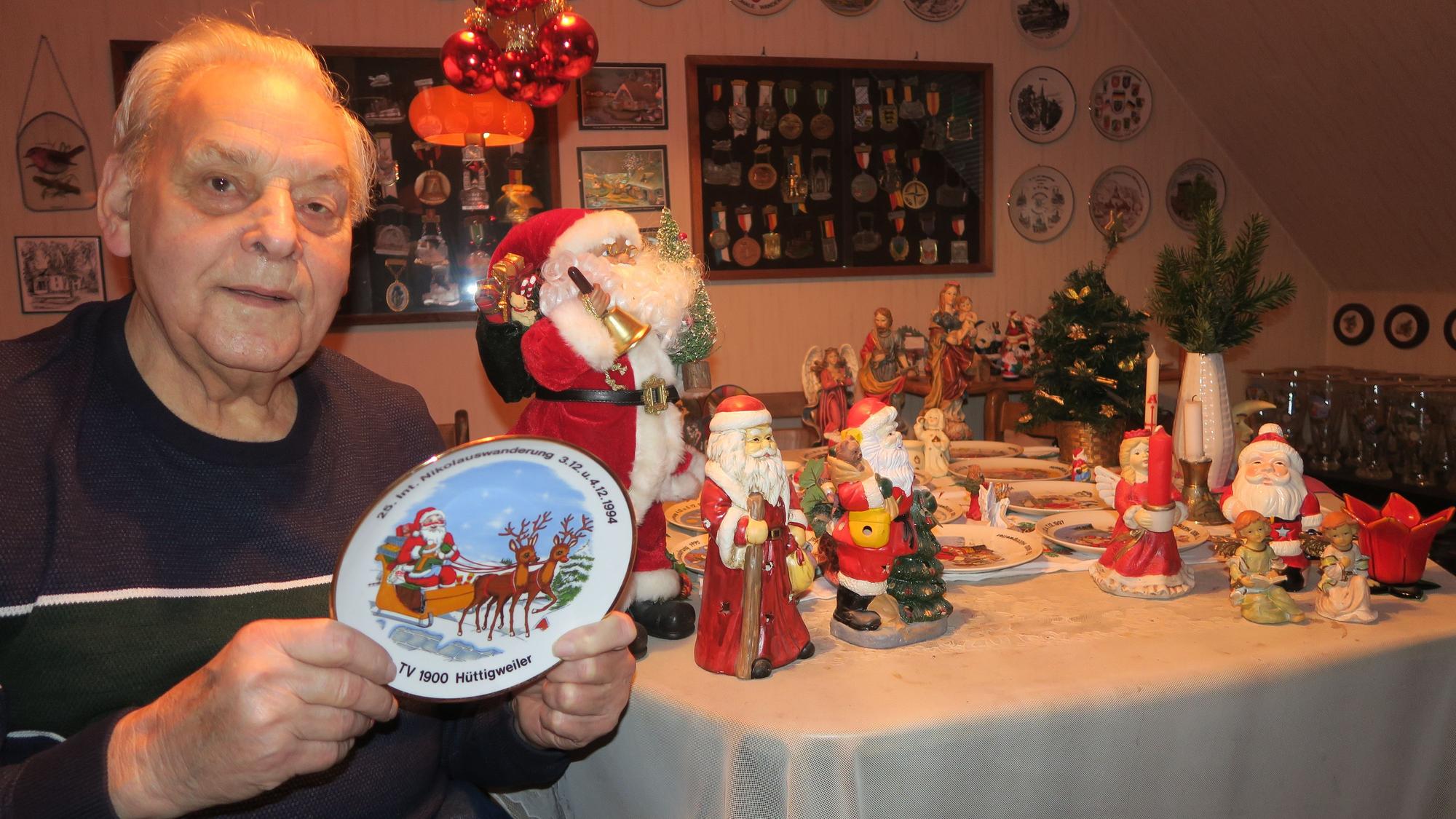 Ein Mann hält einen Teller mit einem Nikolaus, der in einem Rentierschlitten sitzt.