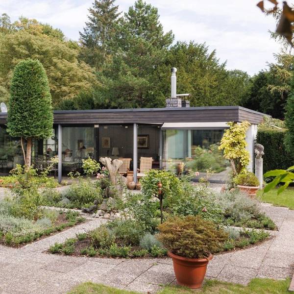 Ein L-förmiger Bungalow in Alt-Hahnwald mit großer Terasse und weitläufigen Garten steht für mehrere Millionen Euro zum Verkauf.
