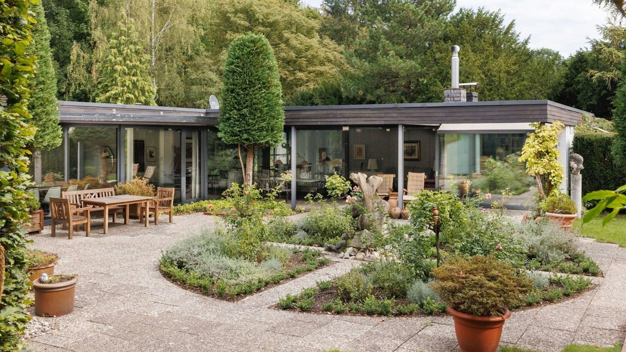 Ein L-förmiger Bungalow in Alt-Hahnwald mit großer Terasse und weitläufigen Garten steht für mehrere Millionen Euro zum Verkauf.