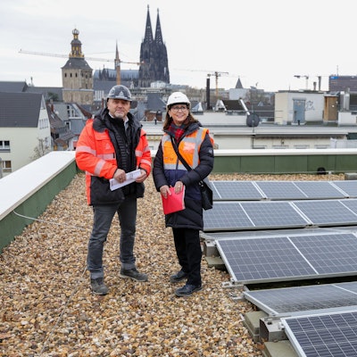 Matthias Zoppelt und Petra Rinnenburger auf dem Dach des Hansa-Gymnasiums in Köln. Im Hintergrund sieht man den Kölner Dom.