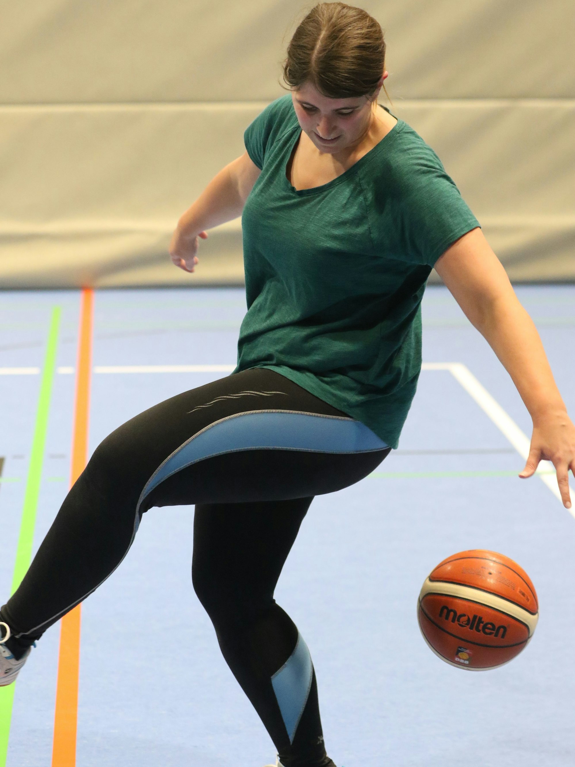 Juli Reuß versucht, einen Basketball hinter ihrem Körper zu dribbeln.