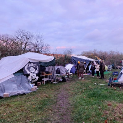 Patrick Timms, eine ehemalige Zeltlagerbewohnerin, Jacek Pinkowsky, Akiko Arendt und Tom Küven (v.l.) im Zeltlager für Obdachlose neben dem autonomen Zentrum (AZ).