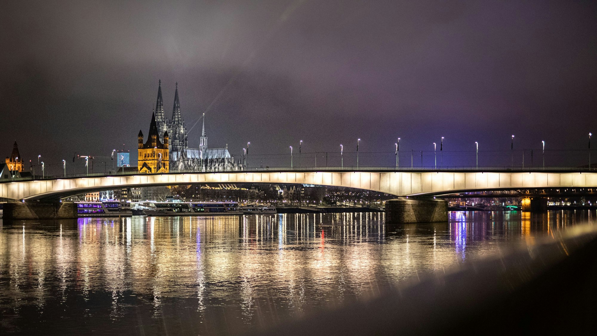 Das Panorama der Stadt Köln mit Kölner Dom und der Kirche Groß St. Martin ist hinter der Deutzer Brücke zu sehen.