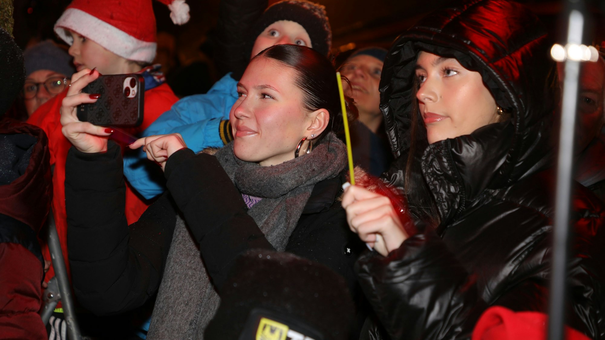 Eine junge Frau filmt den Auftritt mit ihrem Handy.