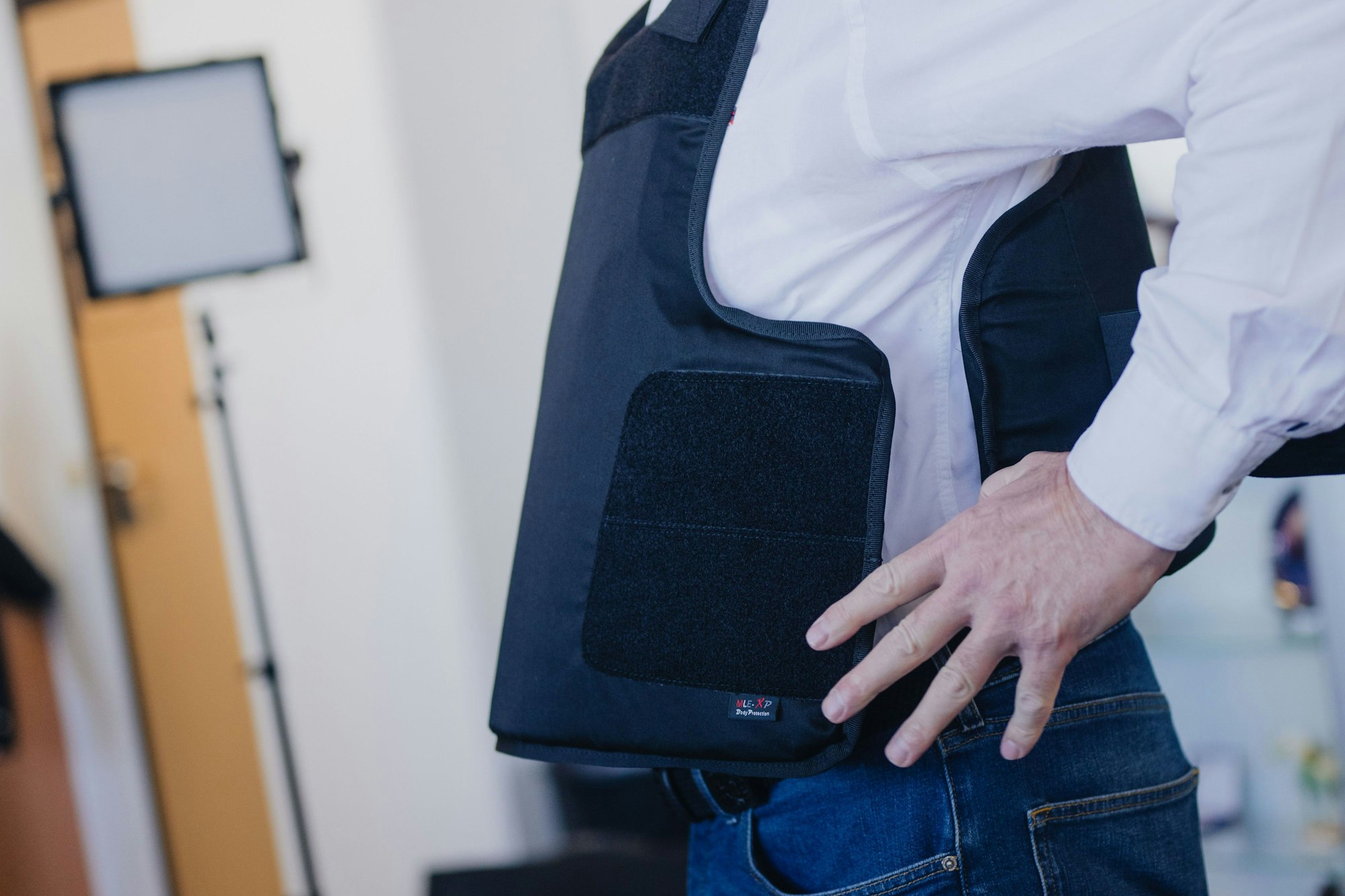 Ein Gerichtsvollzieher zieht während eines Pressetermins seine neue Schutzweste an.