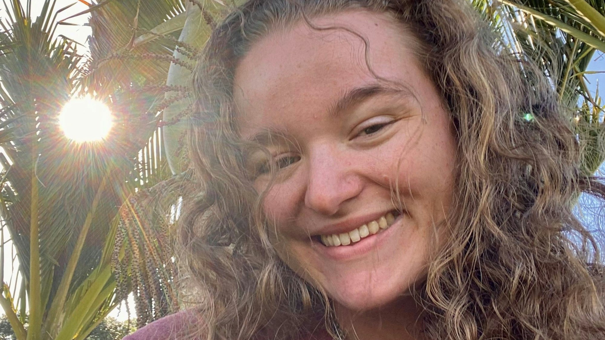 Lea Hirschfeld mit Palmen im Hintergrund.
