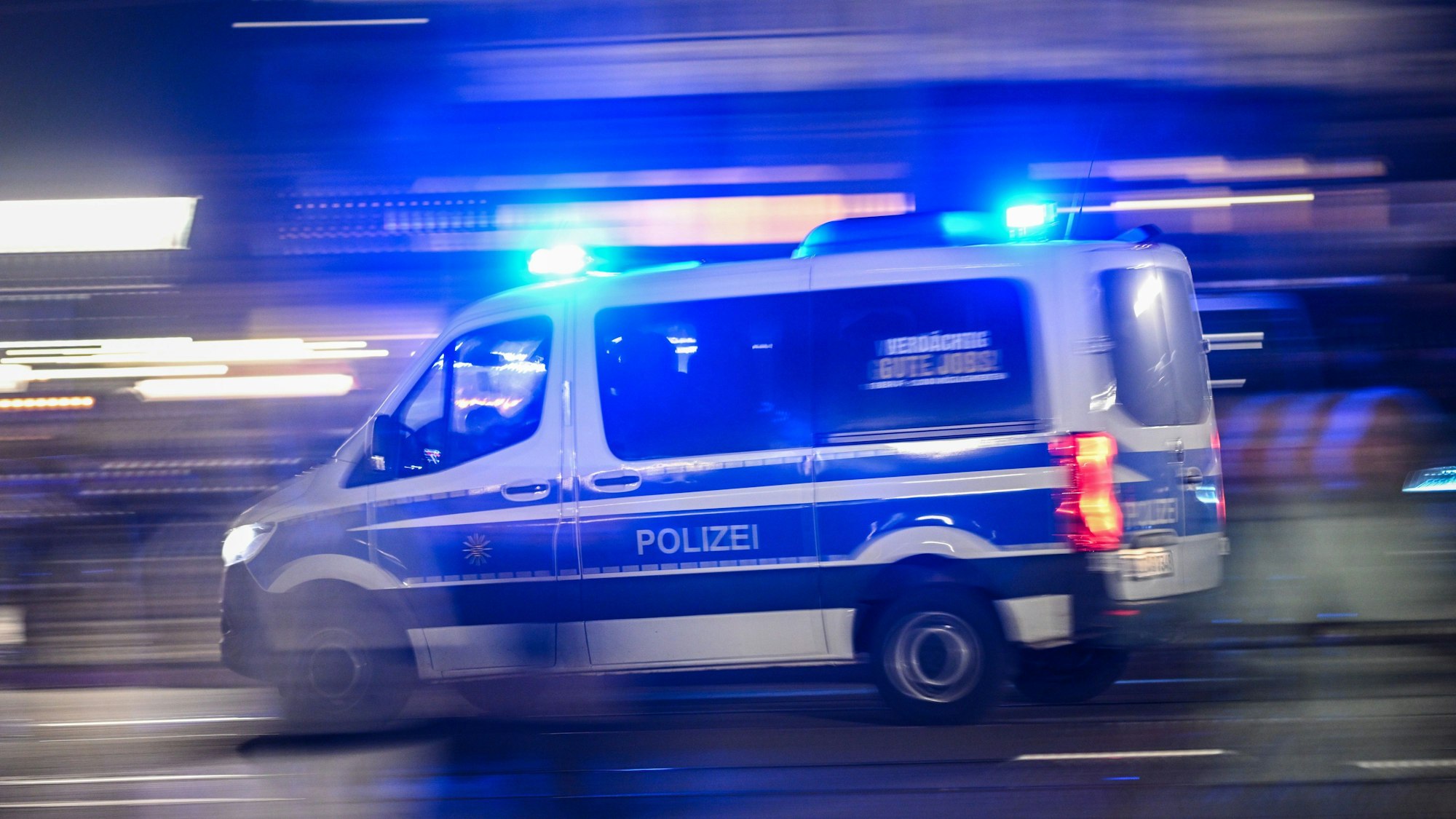 Ein Polizeiauto fährt mit Blaulicht.