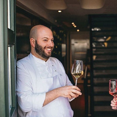 Daniel und Stephanie Lengsfeld mit Weingläsern in der Hand im Eingang ihres Gasthauses Scheiderhöhe.