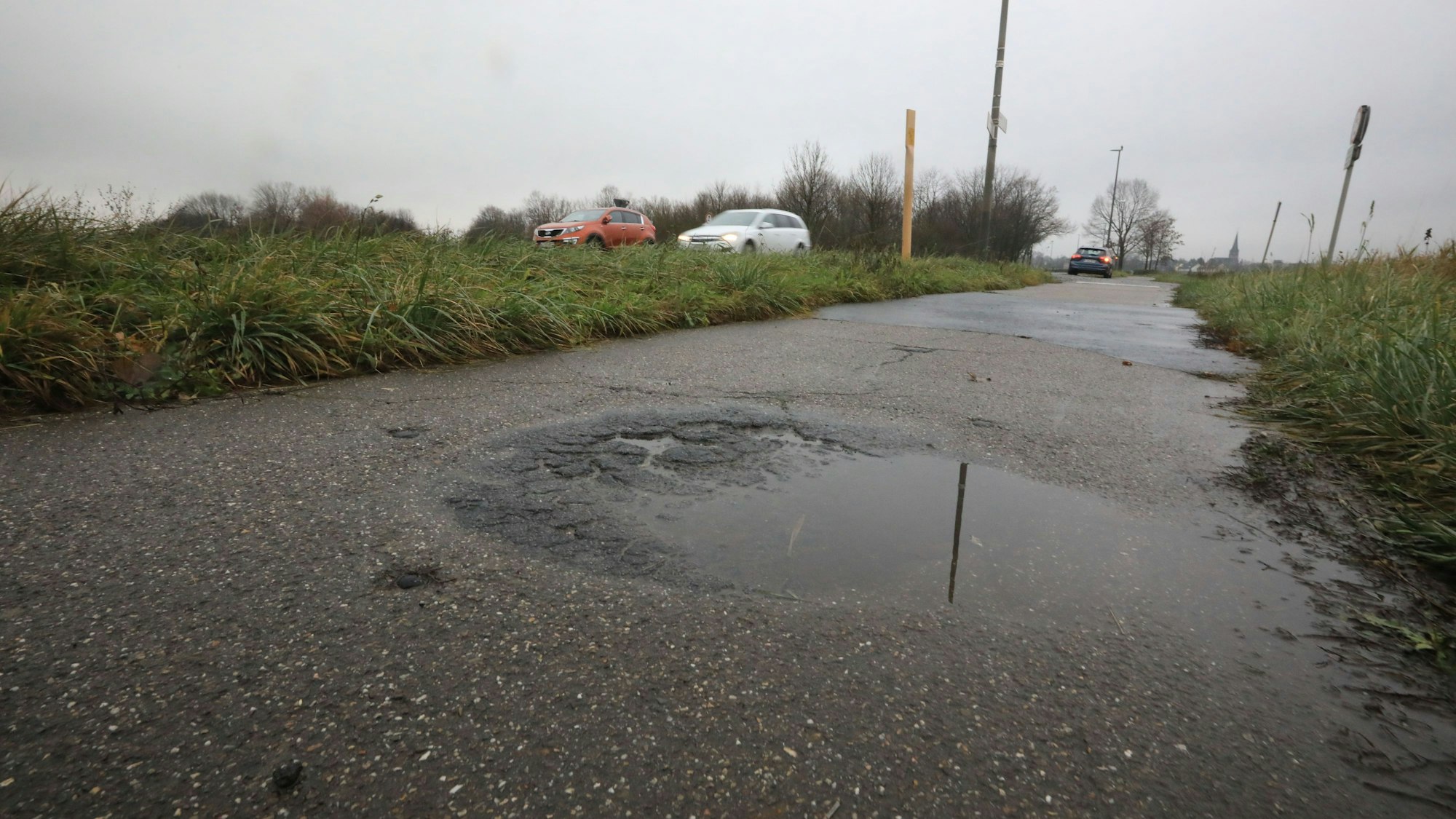 Ein Schlagloch, das sich mit Regenwasser gefüllt hat, ist zu sehen.