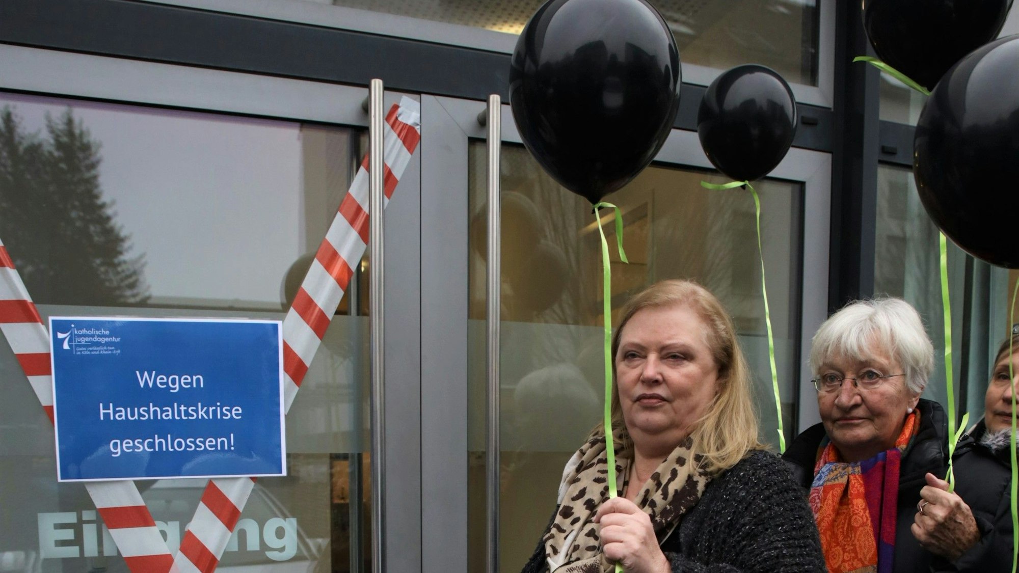 Drei Frauen stehen an einer Tür.