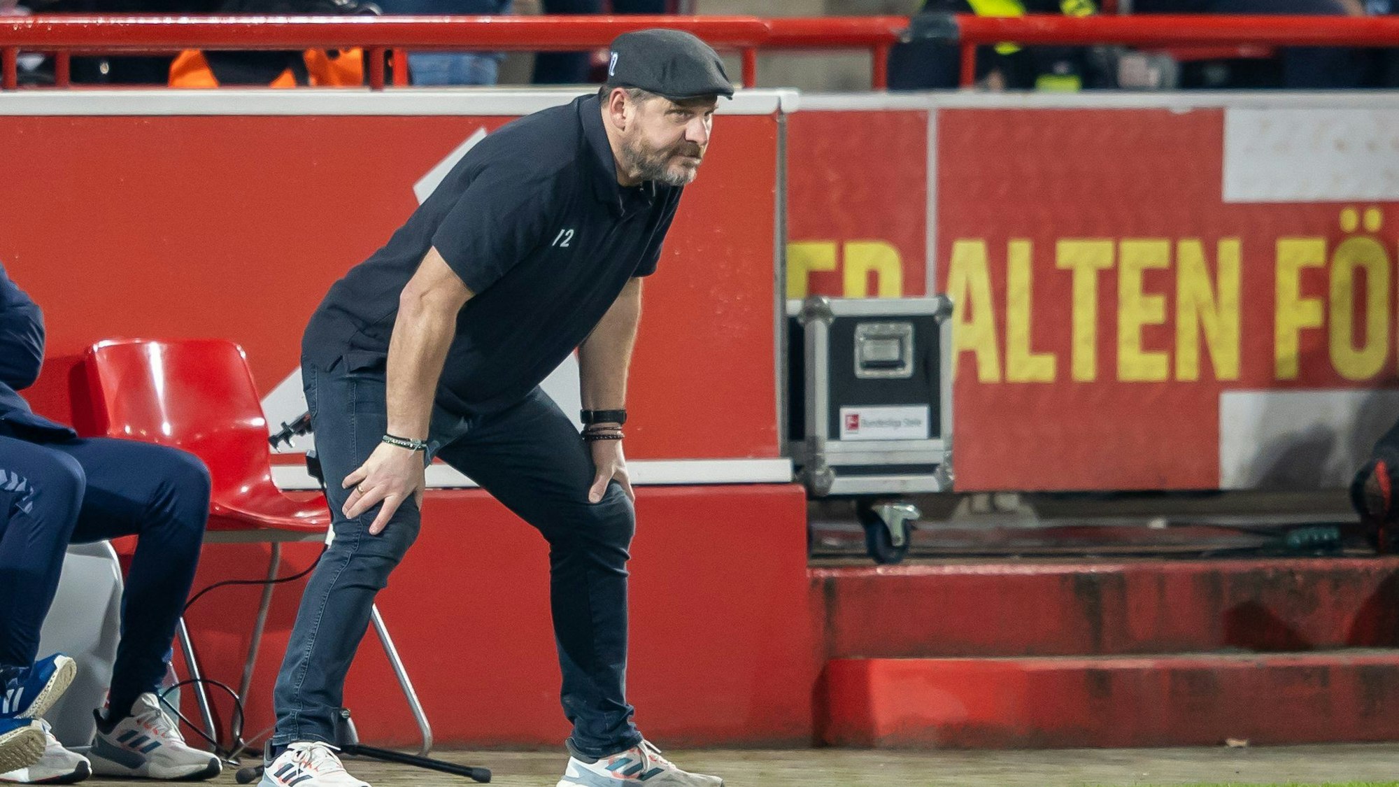 Baumgart steht mit Händen auf den Knien an der Seitenlinie