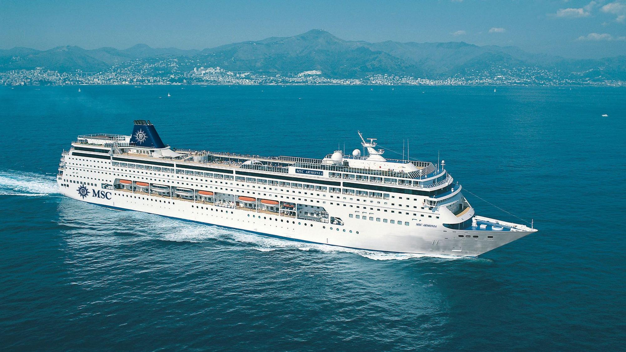 Das Kreuzfahrtschiff „MSC Armonia“ fährt vor einer Küstenstatd durch den Ozean. An Bord haben mehr als 2300 Menschen Platz.