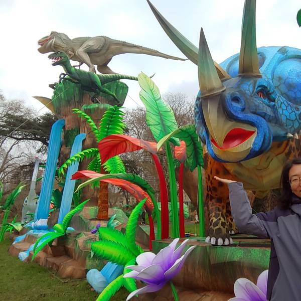 Frau vor einer großen Dinosaurier-Statue