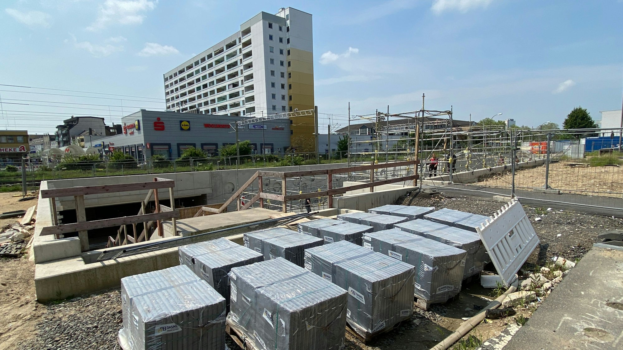 Eine Baustelle vor Gleisen und Hochhäusern in Wesseling.