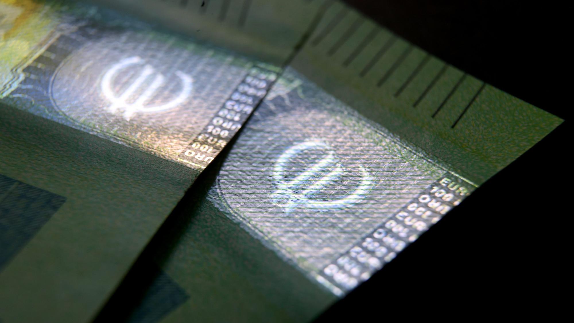 ARCHIV - 27.05.2021, Bayern, Augsburg: 100 Euro Banknoten liegen auf einem Tisch.