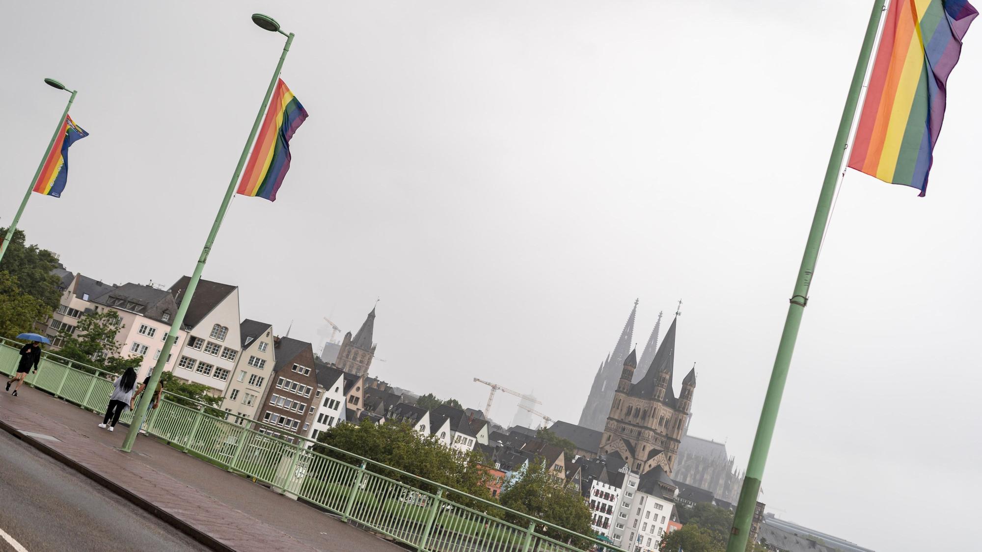 Regenbogen-Flaggen wehen auf der Deutzer Brücke in Köln, im Hintergrund der Kölner Dom und Groß St. Martin (Archivbild)