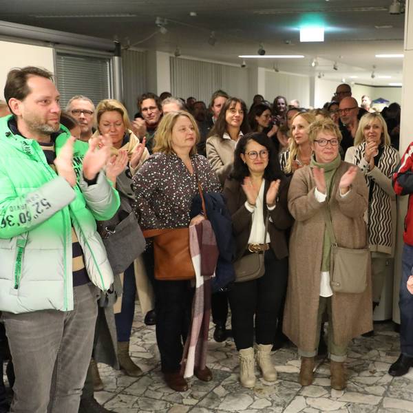 Kreisdirektor Dr. Erik Werdel steht vor der Tür des großen Sitzungssaals im Kreishaus am Rübezahlwald in Bergisch Gladbach. Mehrere Menschen applaudieren ihm