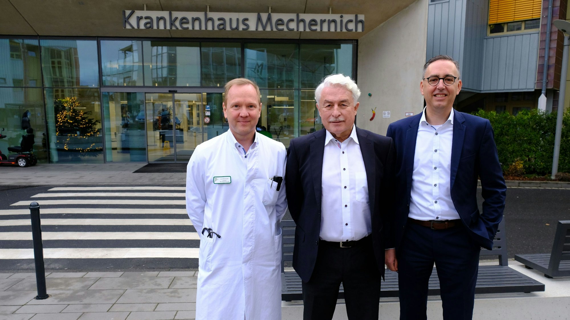 Dr. Peter Wirtz (Mitte), Dr. Ulf Peter Schmidt (l.) und Geschäftsführer Martin Milde stehen vor dem Haupteingang des Krankenhauses in Mechernich.
