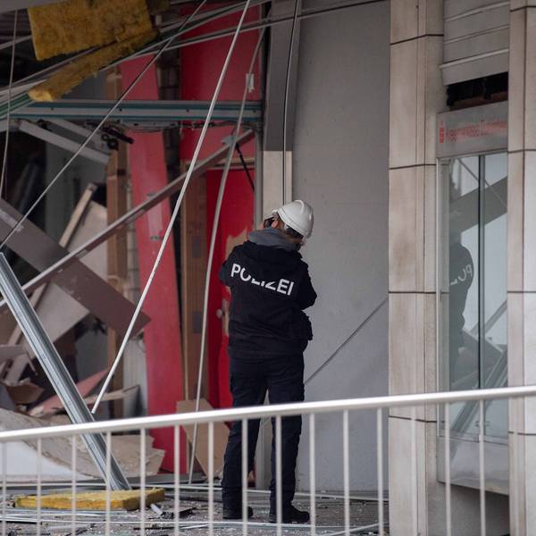 Das Foto zeigt eine Kriminalbeamtin, die die Schäden in der Filiale mithilfe von Fotos dokumentiert.
