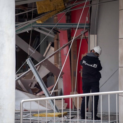Das Foto zeigt eine Kriminalbeamtin, die die Schäden in der Filiale mithilfe von Fotos dokumentiert.