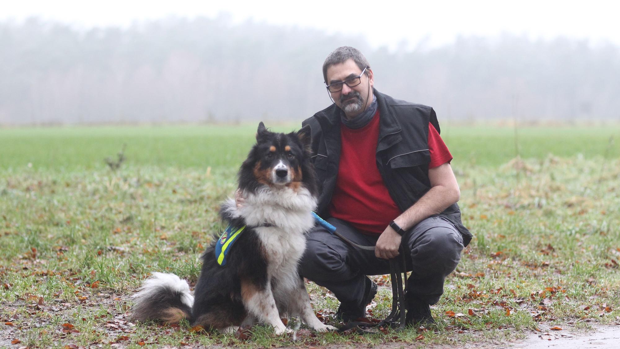 Ein Mann mit Hund an einem Feld