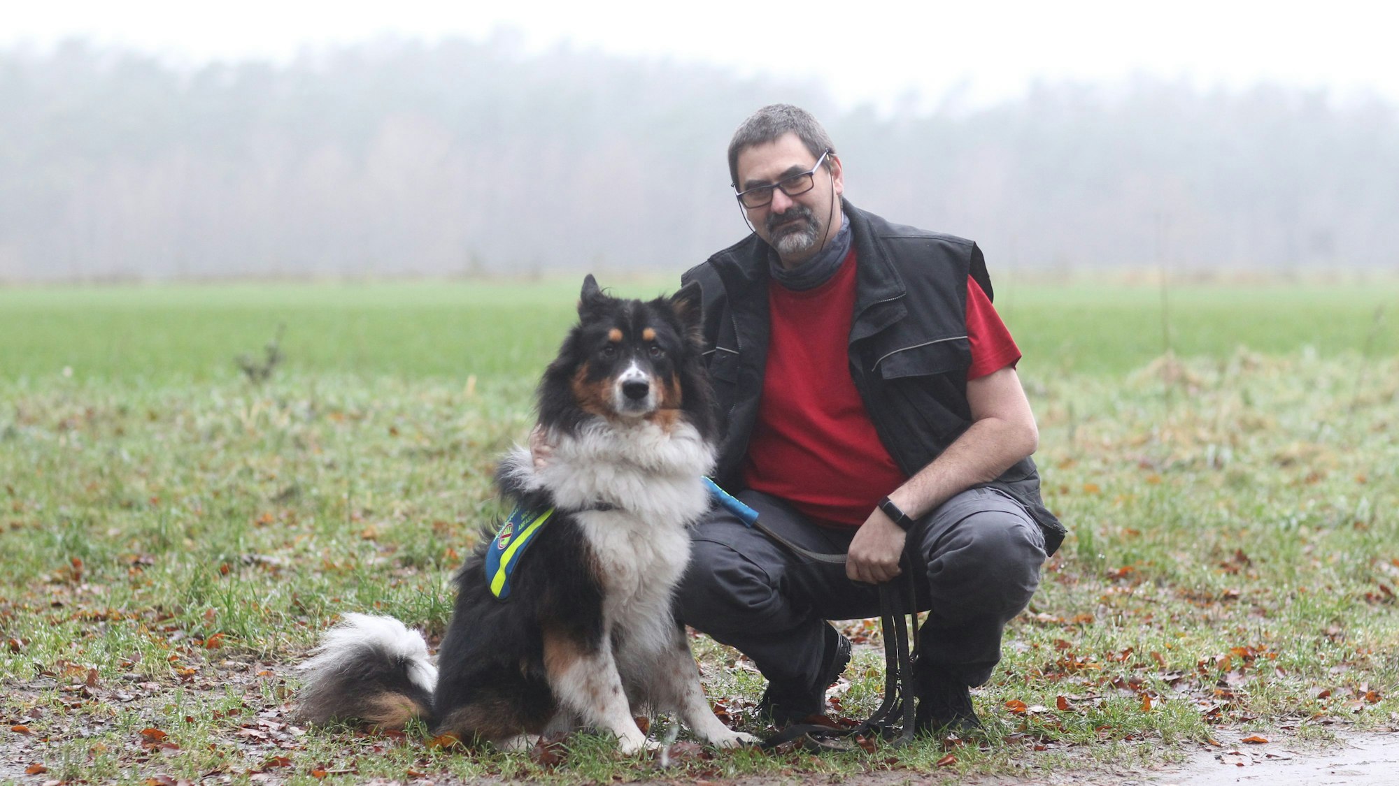 Ein Mann mit Hund an einem Feld