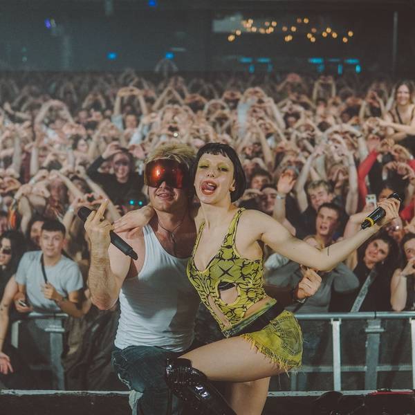 Die Sängerin Domiziana und der Rapper Ski Aggu, beide aus Berlin, posieren im April 2023 auf der Bühne des Kölner Popfestivals c/o pop vor gestikulierenden Fans.