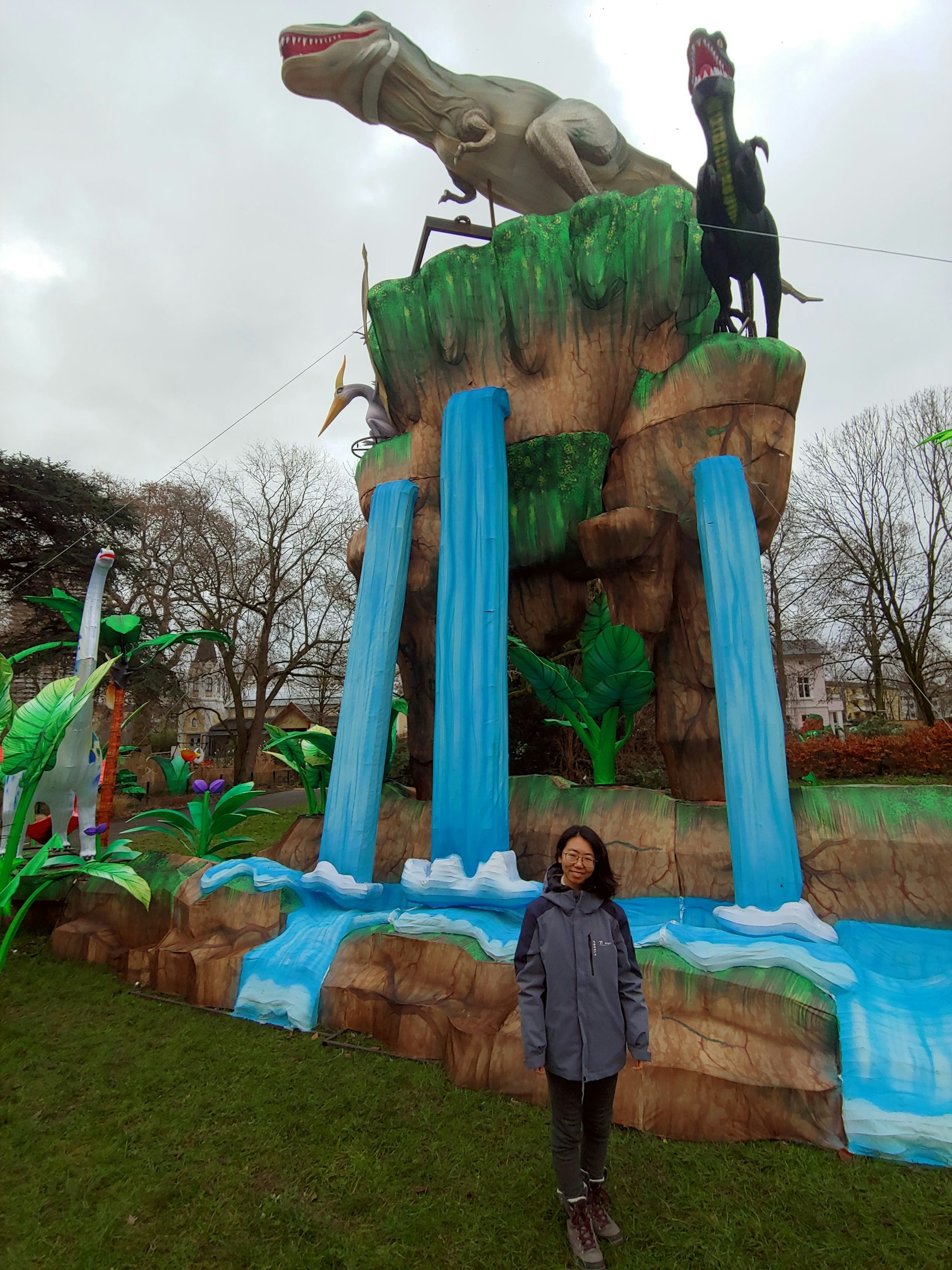 Frau vor zwei Dinosaurier-Statuen
