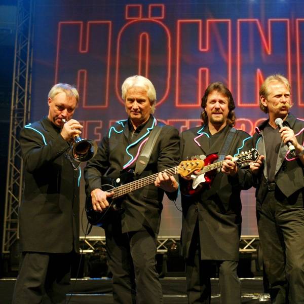 Peter Werner, Hannes Schöner, Pete Bauchwitz, Henning Krautmacher, Janus Fröhlich und Ralf Rudnik stehen im schwarzen Anzug auf einer Bühne.