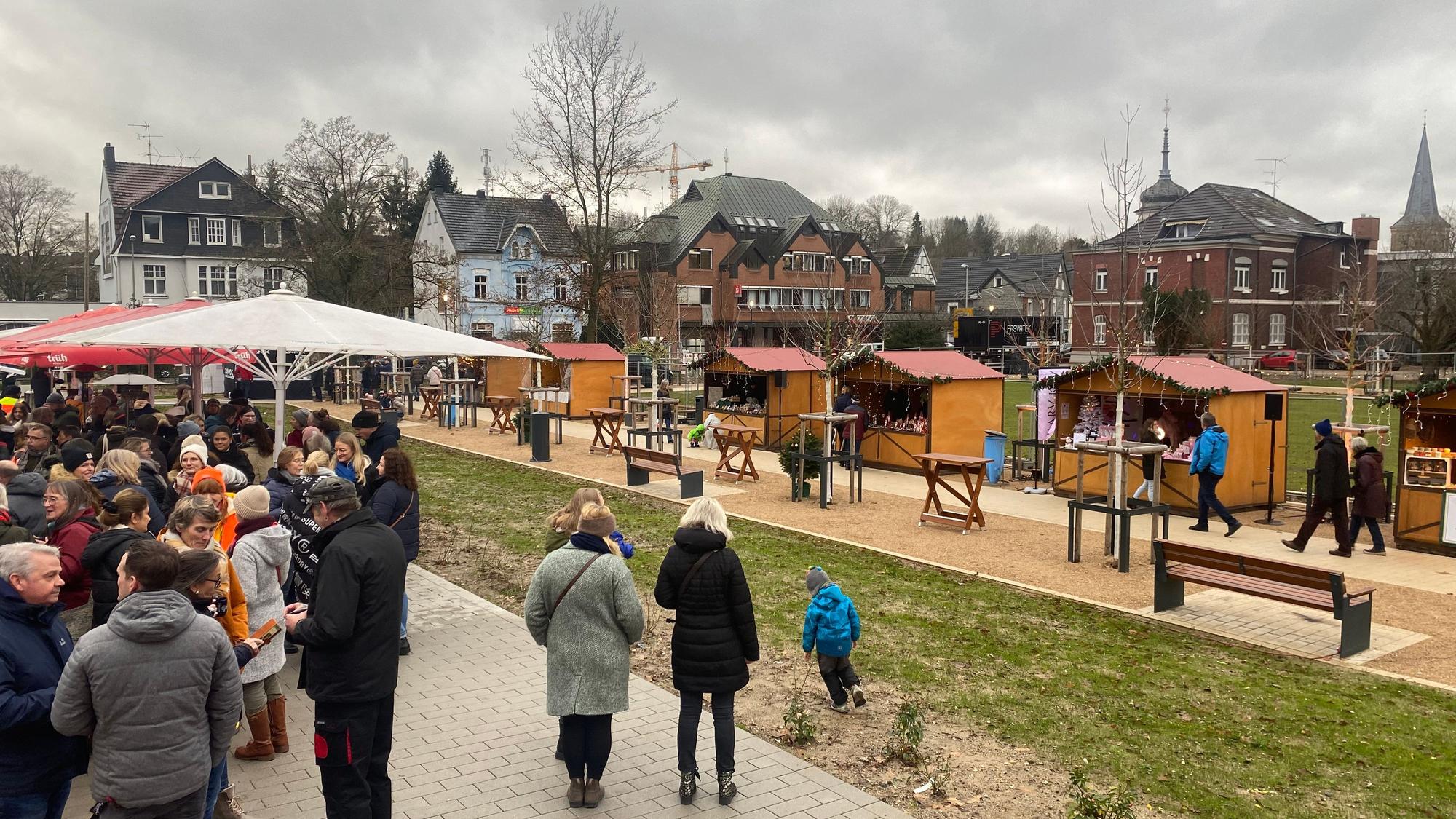 Eine Gruppe von Menschen steht auf einem Weihnachtsmarkt.