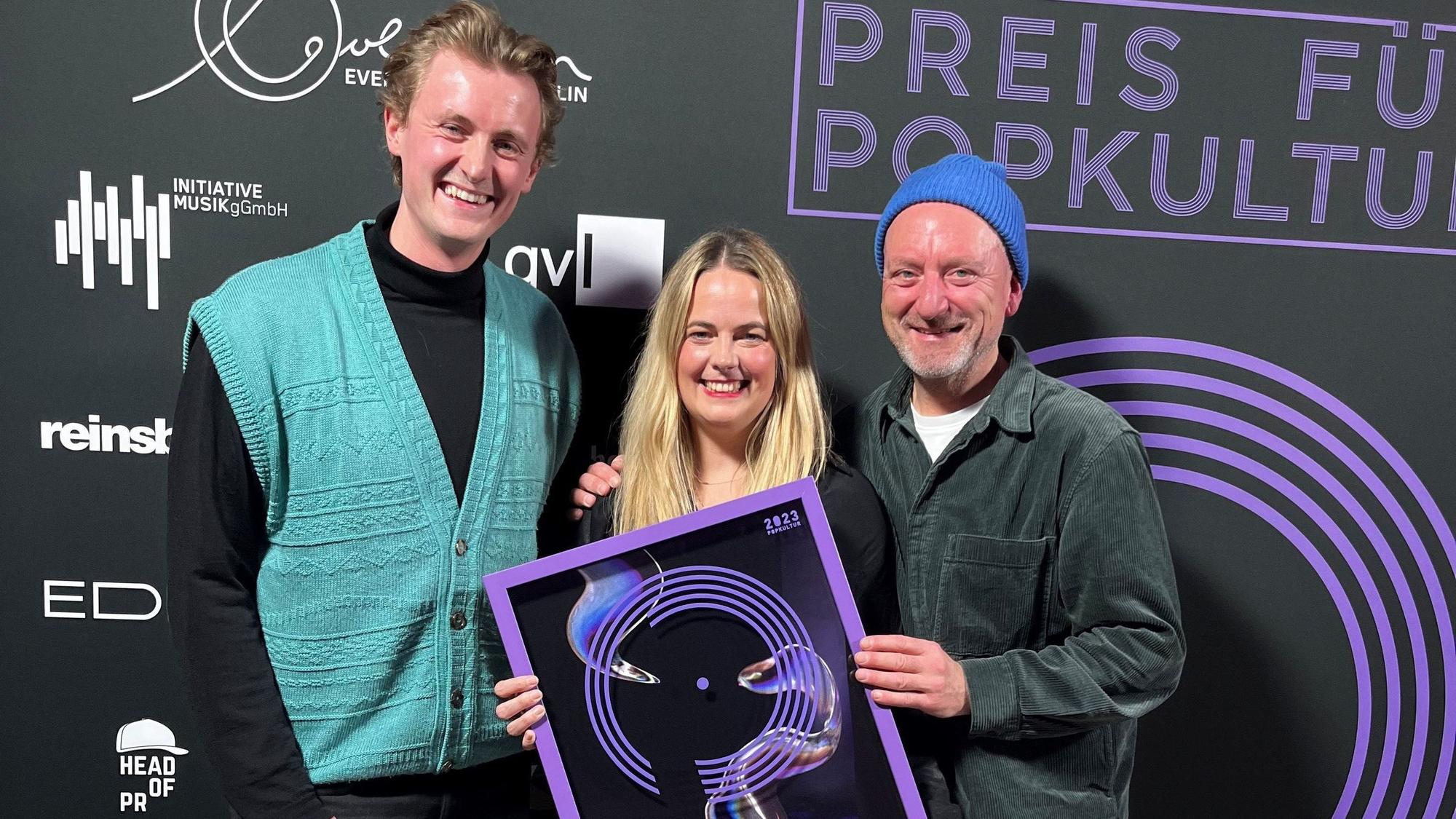 Tim Rummel (v.l.), Carolin Jäger und Ralph Christoph freuen sich in Berlin über den Preis für Popkultur für die c/o pop