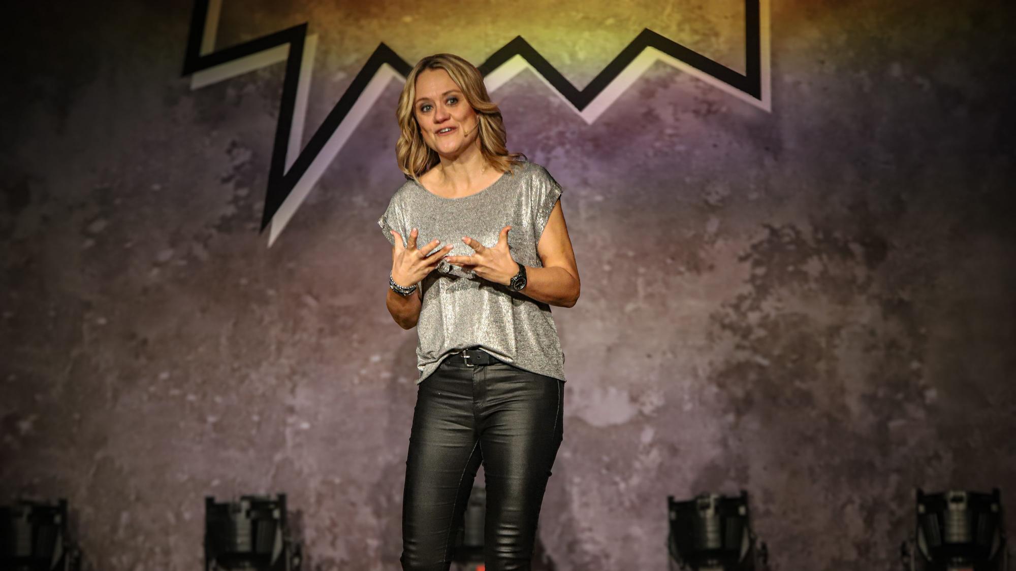 Eine blonde Frau steht auf einer Bühne