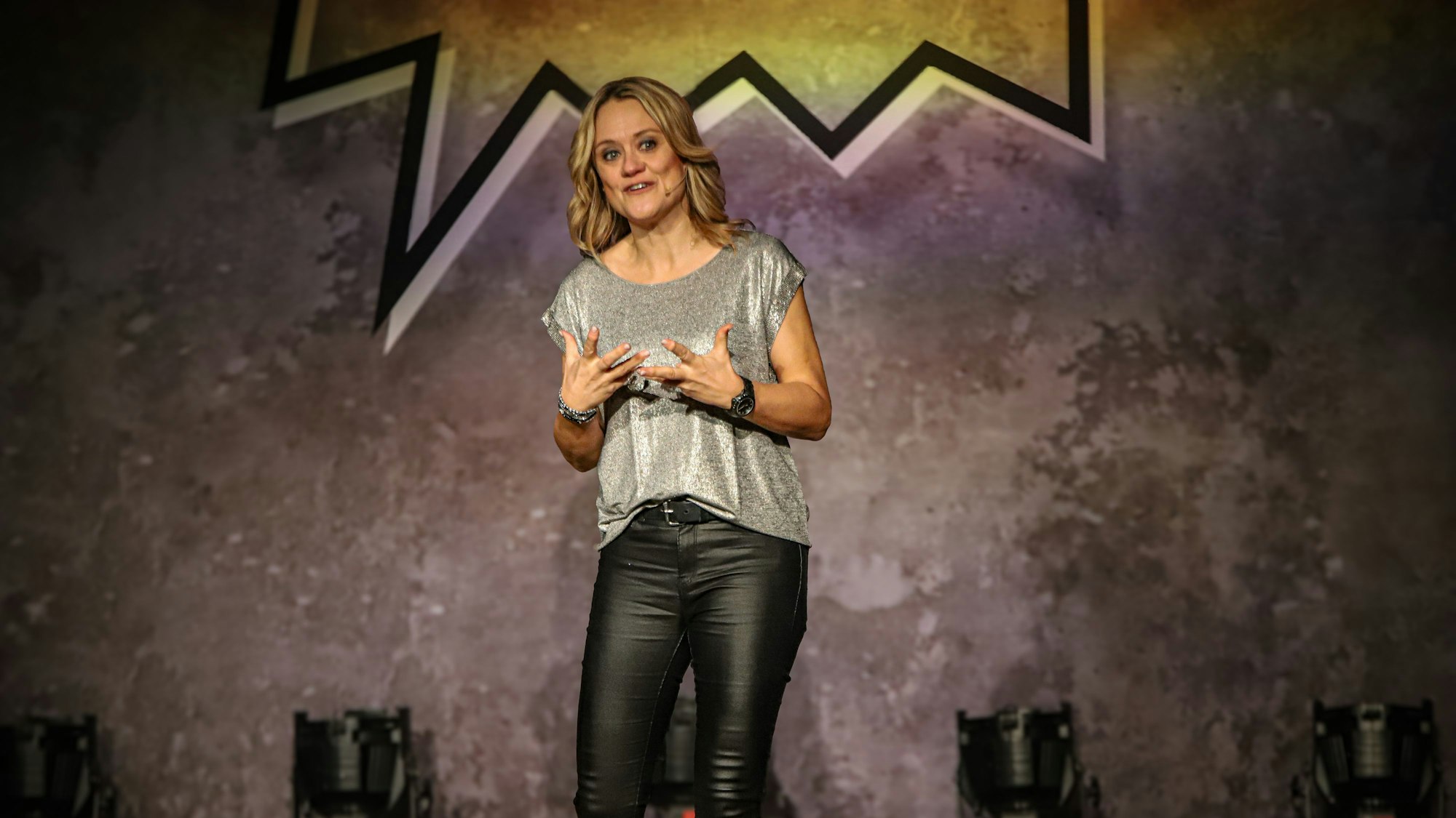 Eine blonde Frau steht auf einer Bühne