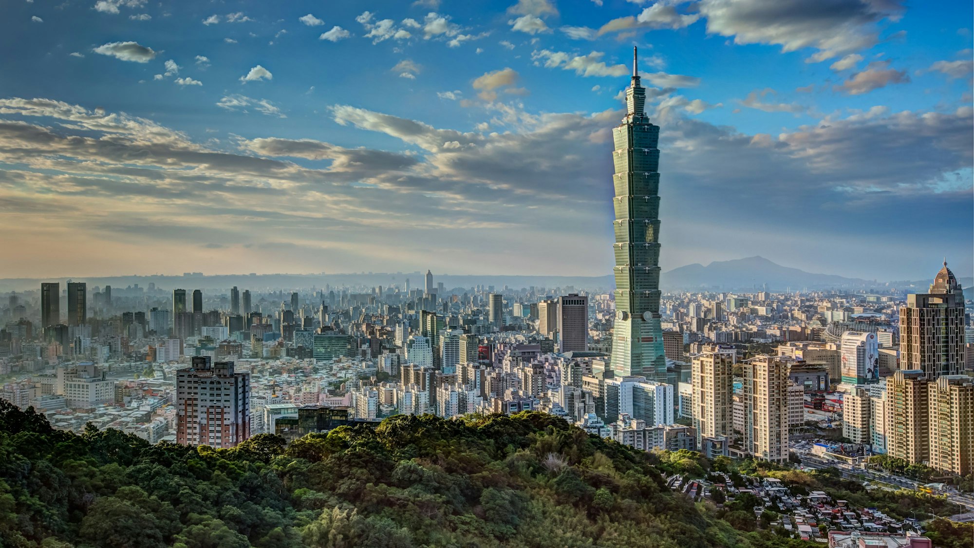 HDR-Aufnahme des Sonnenuntergangs in Taipeh mit baumwollartigen Wolken am blauen Himmel.