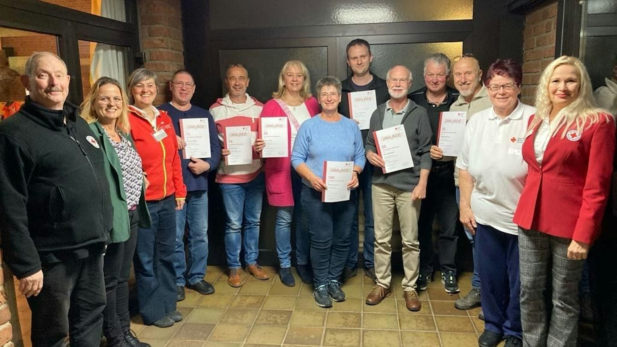 In einer Gruppe Menschen halten einige Urkunden in Händen.