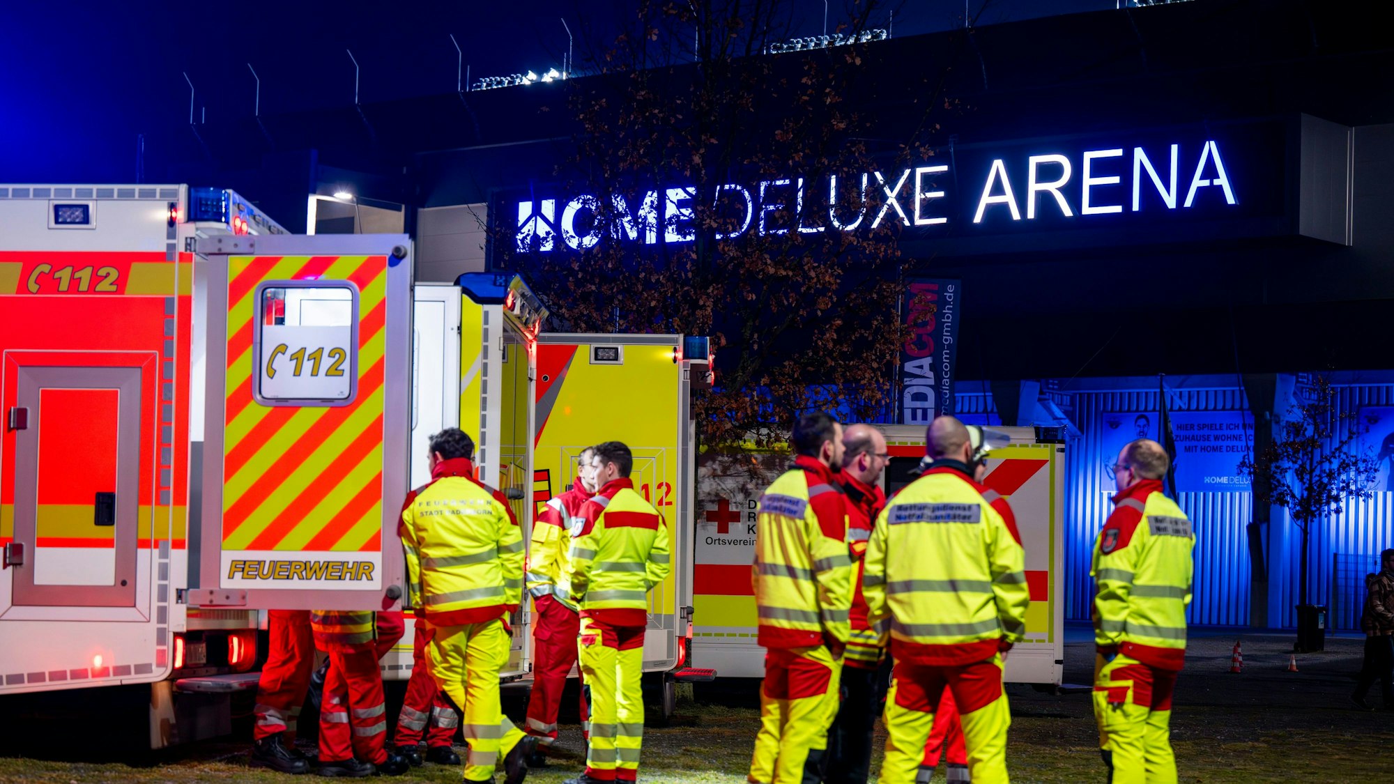 Sanitäter stehen vor dem Stadion in Paderborn bei einem Einsatz vor ihren Rettungswagen.