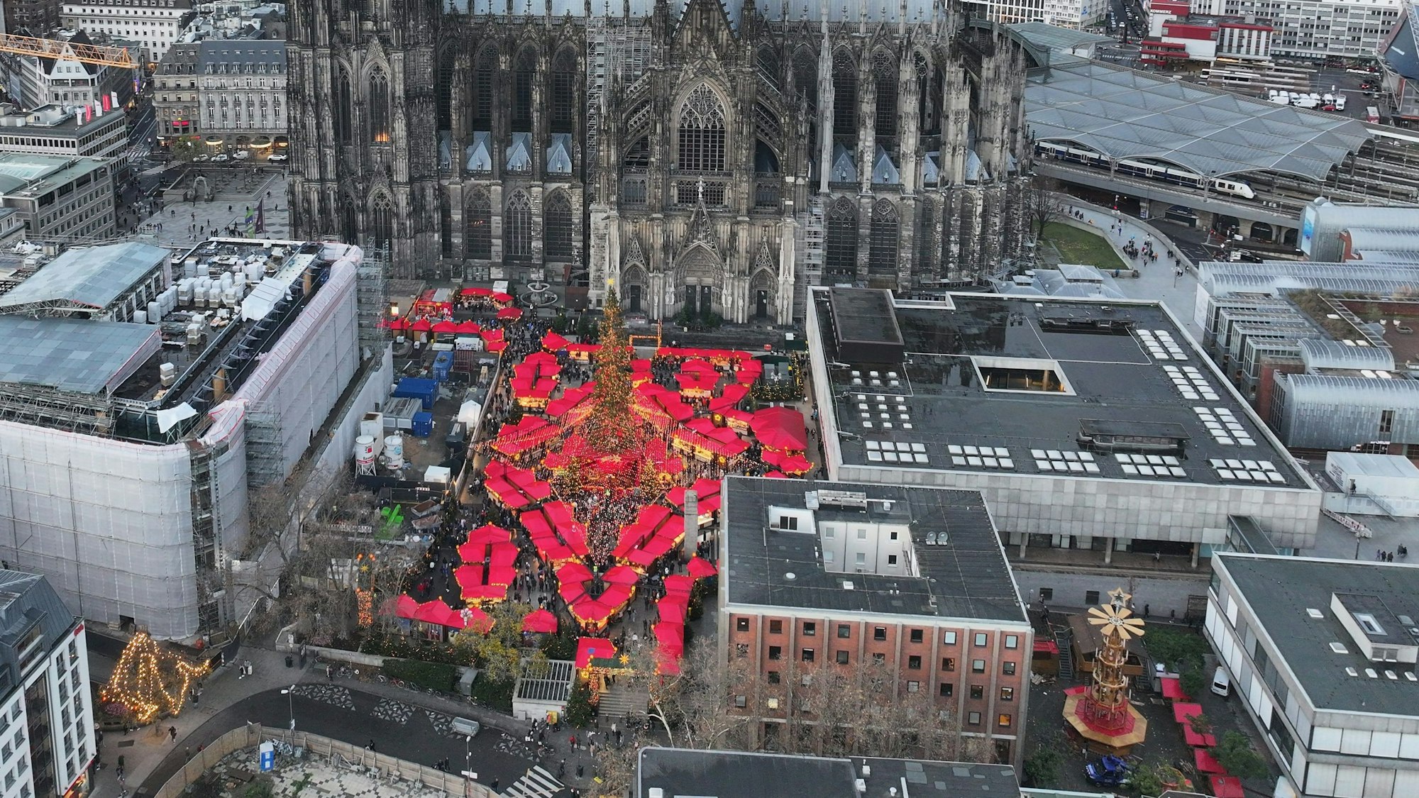 Der Roncalliplatz von oben: Links das Dom-Hotel, in der Mitte der Weihnachtsmarkt, rechts das Römisch-Germanische Museum (RGM), davor das Kurienhaus (rote Klinker) und das Studienhaus des RGM.