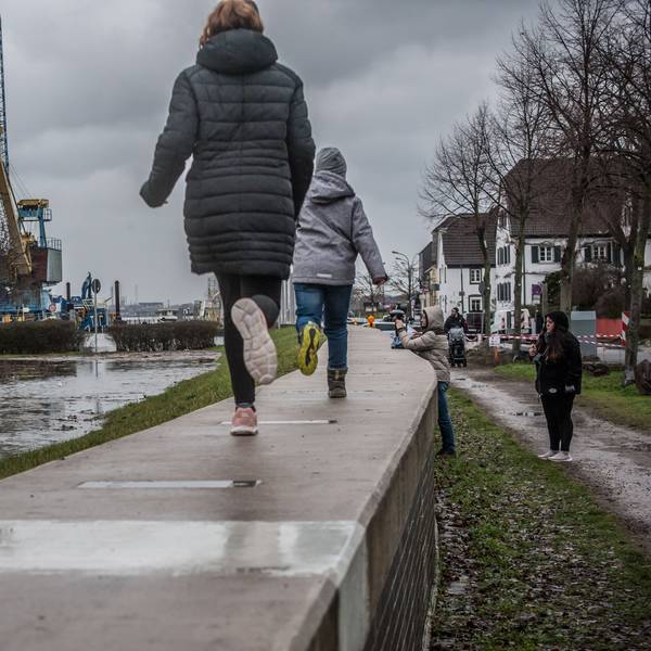 Kinder laufen am Rhein in Hitdorf entlang.