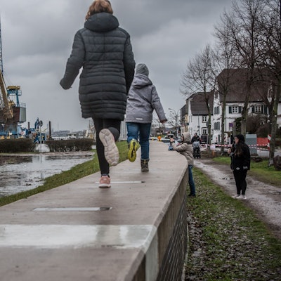 Kinder laufen am Rhein in Hitdorf entlang.