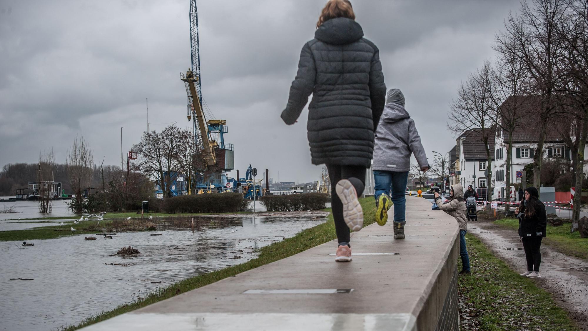 Kinder laufen am Rhein in Hitdorf entlang.