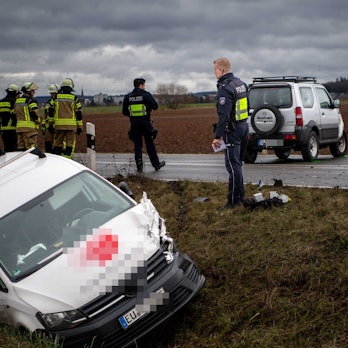 Das Bild zeigt die Szenerie des Unfalls. Ein Auto liegt im Graben, das andere etwa zehn Meter entfernt. Es steht auf der Straße. Auch Polizisten und Feuerwehrleute sind an der Einsatzstelle.