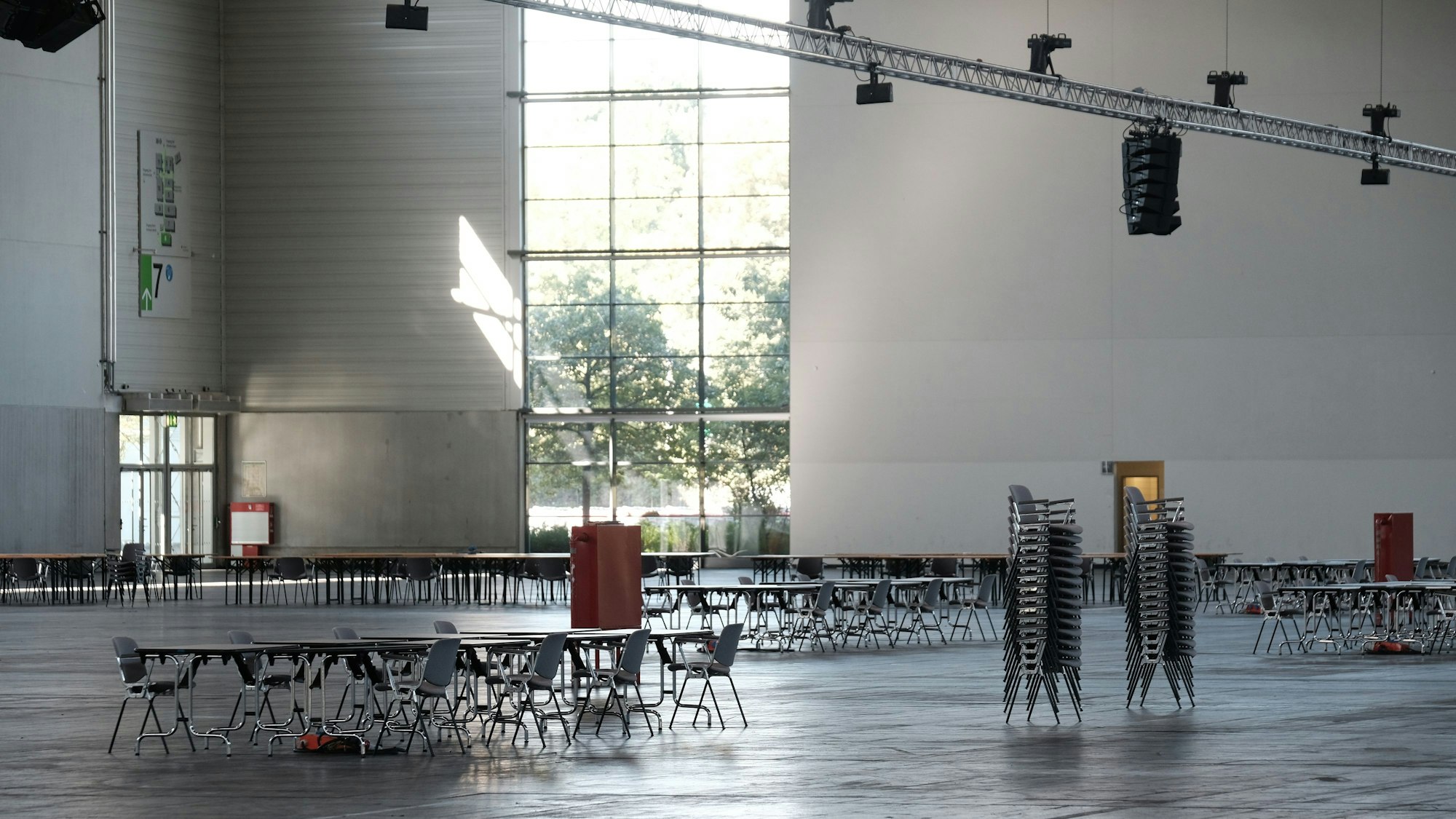In einer ansonsten leeren Halle der Köln-Messe in Köln-Deutz stehen Stühle herum.