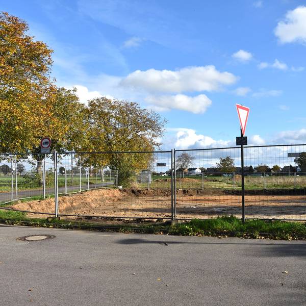 Ein Bauzaun umgibt eine frisch ausgeschachtete Baustelle.