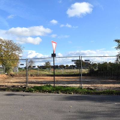 Ein Bauzaun umgibt eine frisch ausgeschachtete Baustelle.