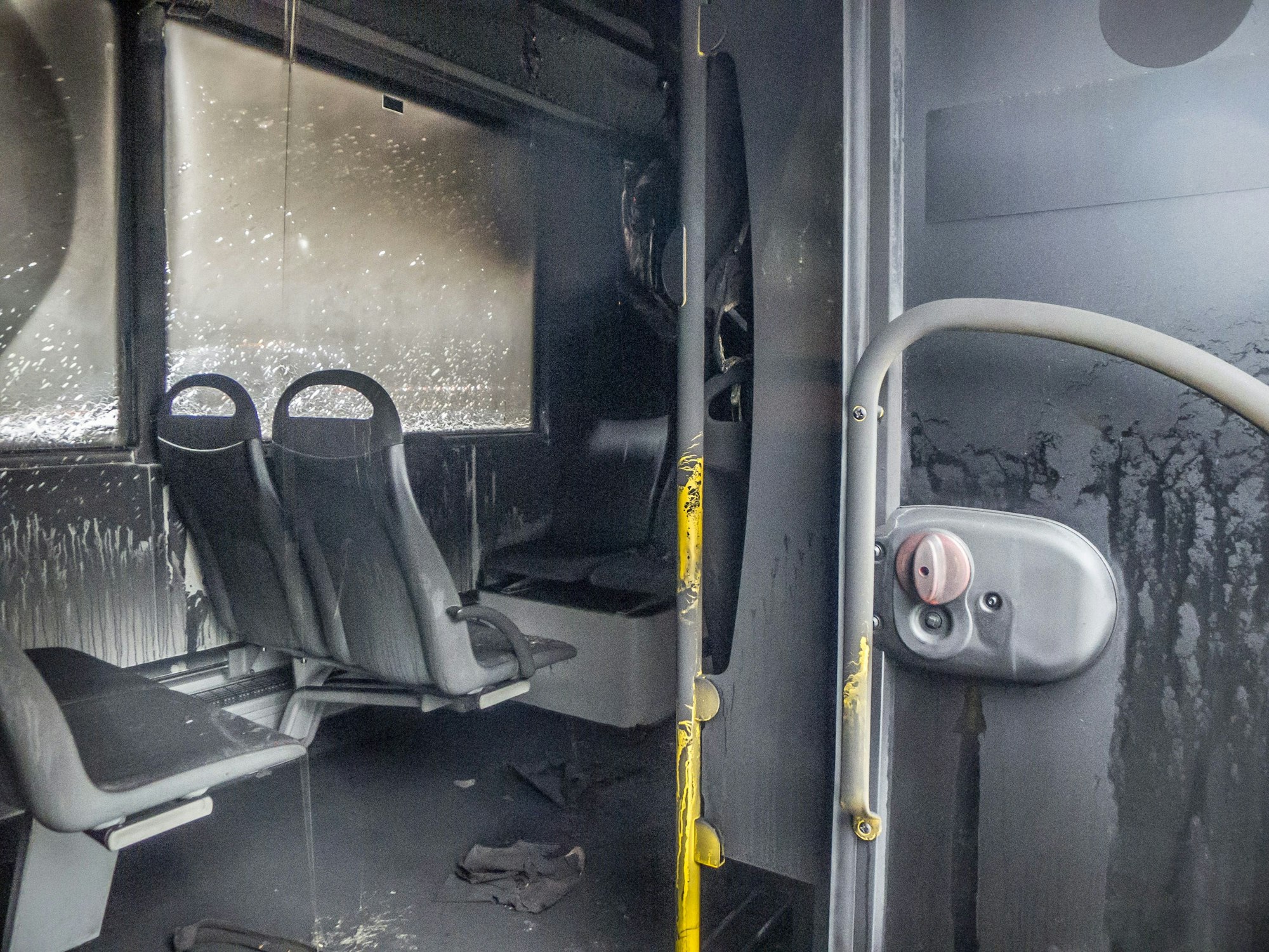 Ein ausgebrannter Wupsi-Bus wird vom Abschleppdienst an den Haken genommen. Foto: Ralf Krieger