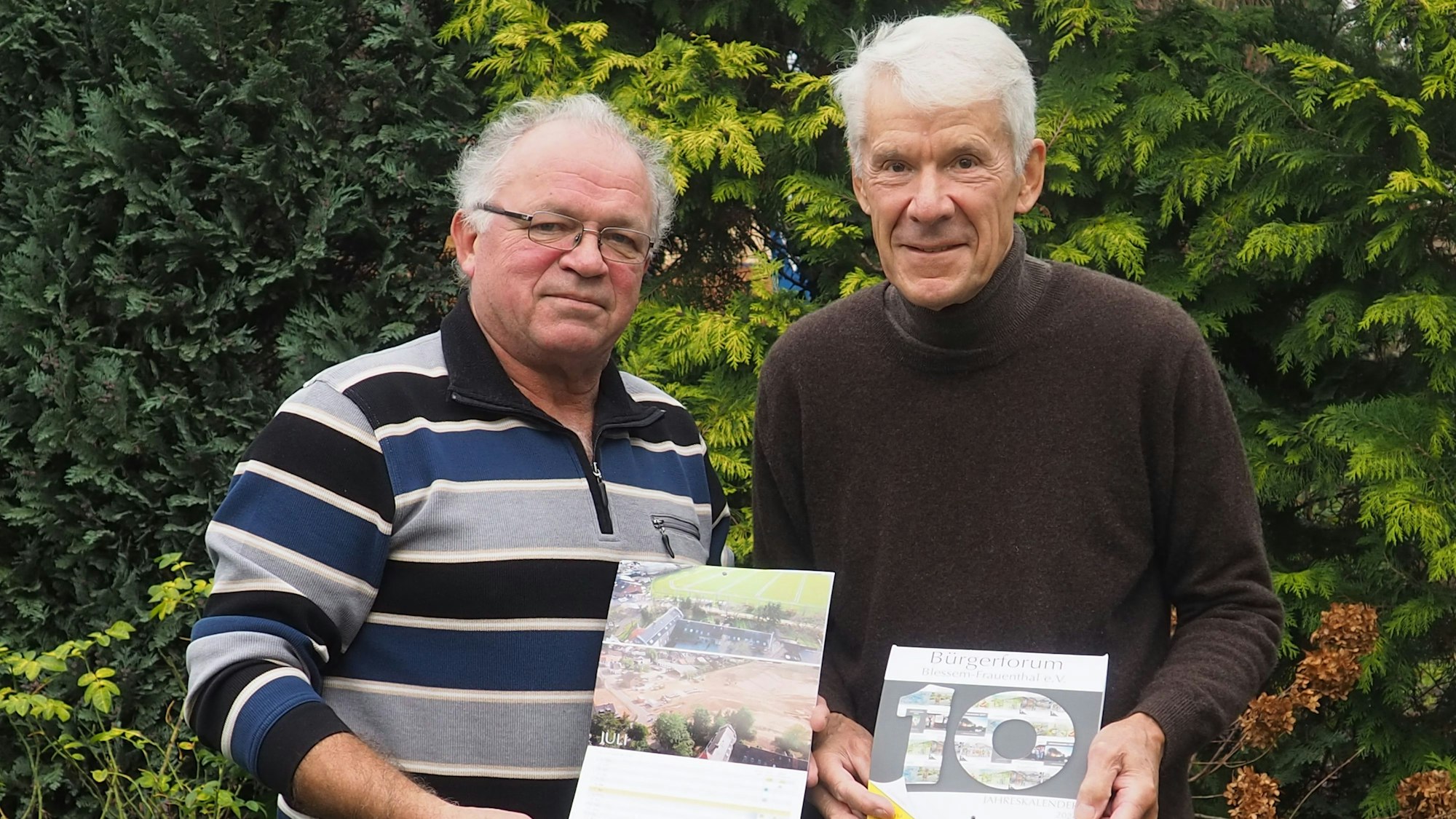 Zwei Männer zeigen den Kalender.