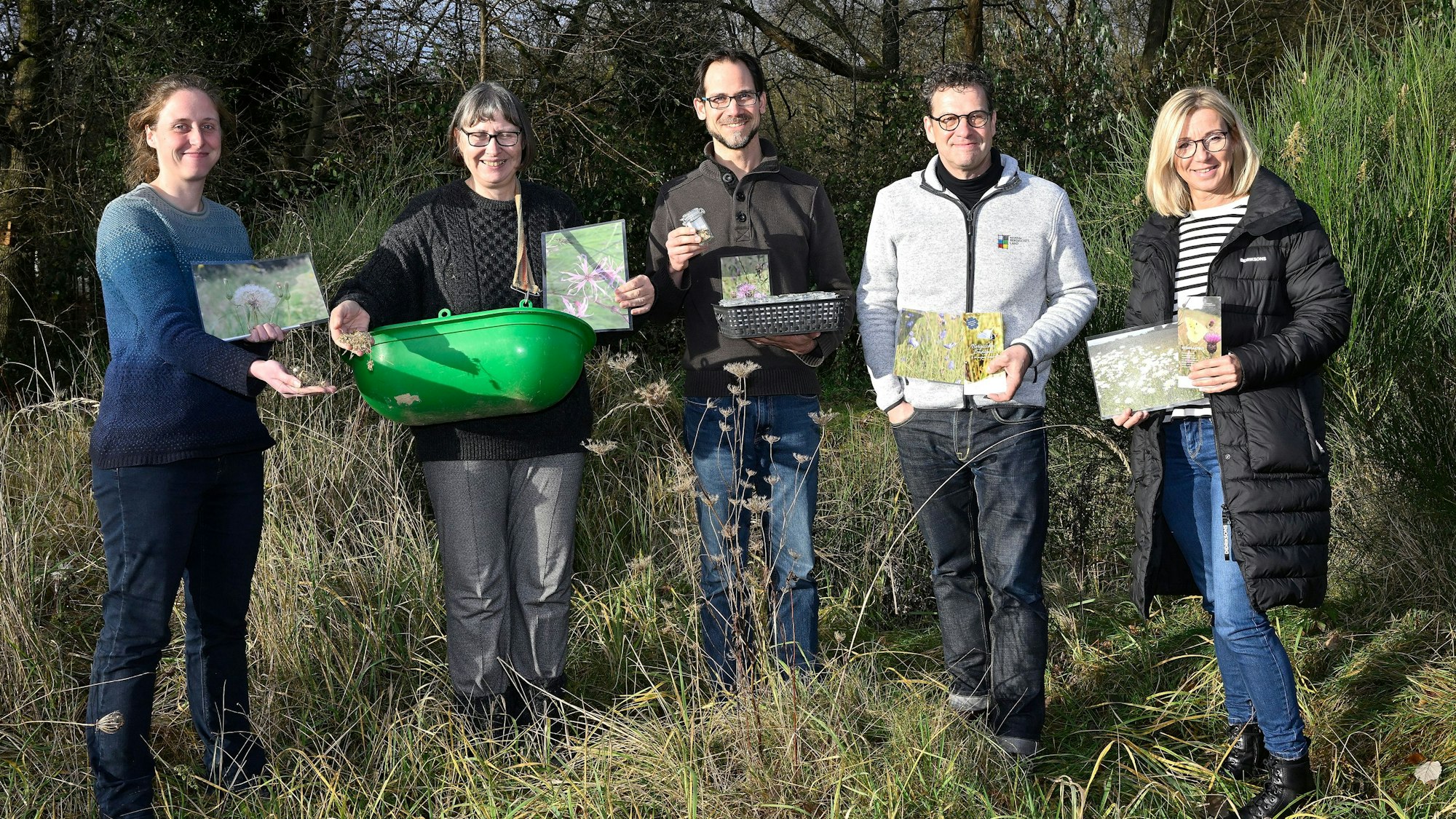 Cornelia Lösche, Christine Wosnitza und Tobias Mika von den Biostationen mit Jens Eichner und Ariane Kautschke (Naturpark) stehen mit Saatgut und Broschüren in den Händen auf einer Wiese.
