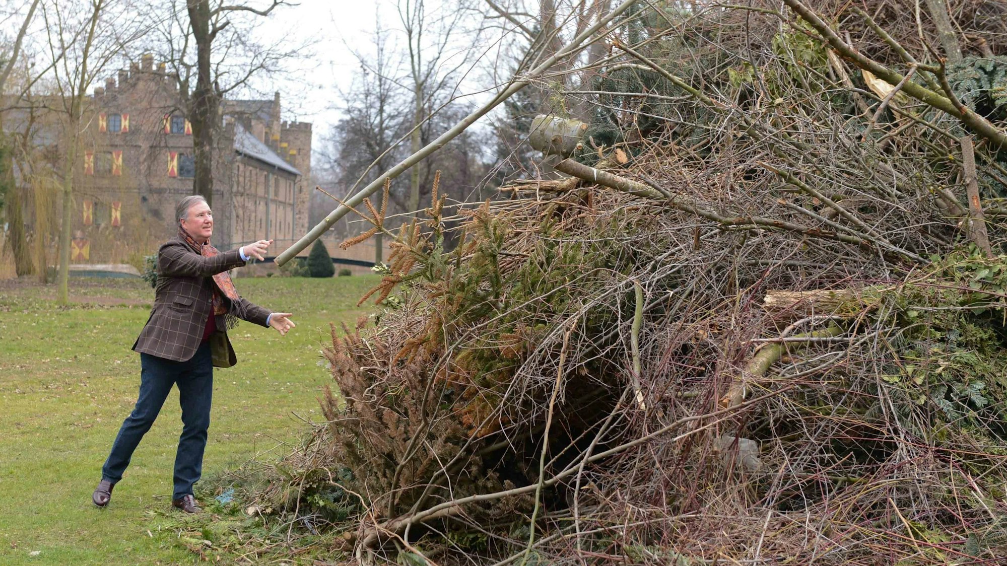 Der Burgherr hat fürs Osterfeuer Baumschnitt angehäuft, im Hintergrund die Burg.