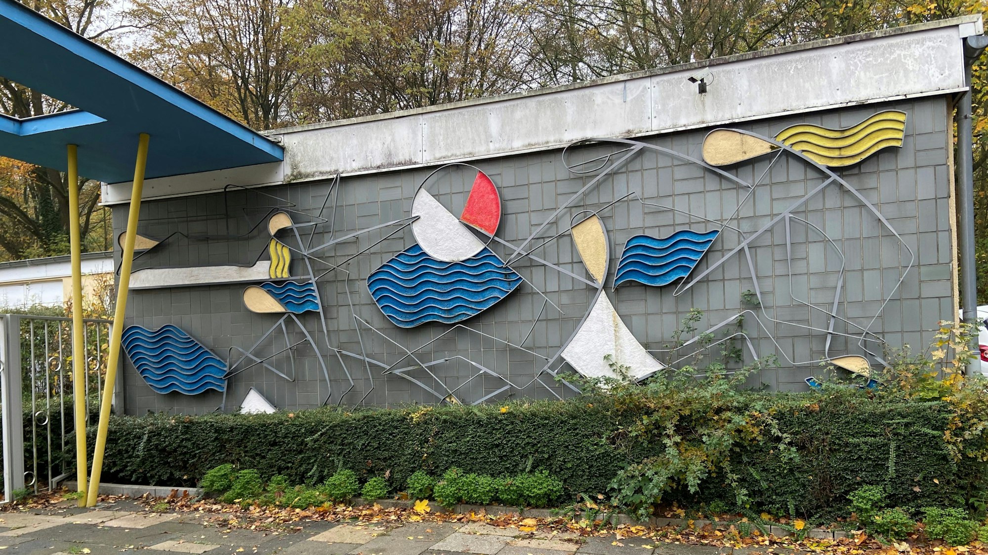 Zu sehen ist ein Wanderelief mit wellenförmigen Elementen in Blau, Rot und Gelb.