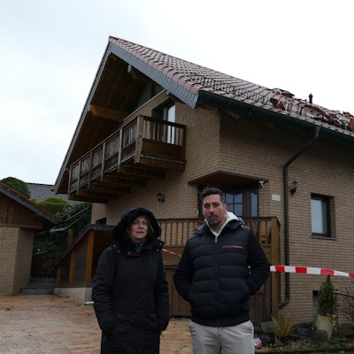 Christine und Florian Staubach vor ihrem Haus in der Dorfstraße in Lohmar-Krahwinkel, dessen Dach komplett zerstört ist. Hinein dürfen sie nicht mehr.